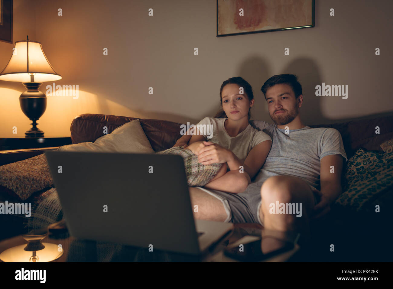 Couple using laptop in living room Stock Photo