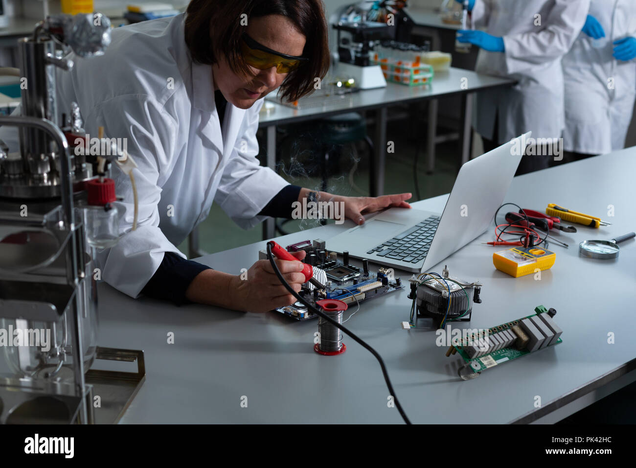 Female scientist soldering circuit board Stock Photo