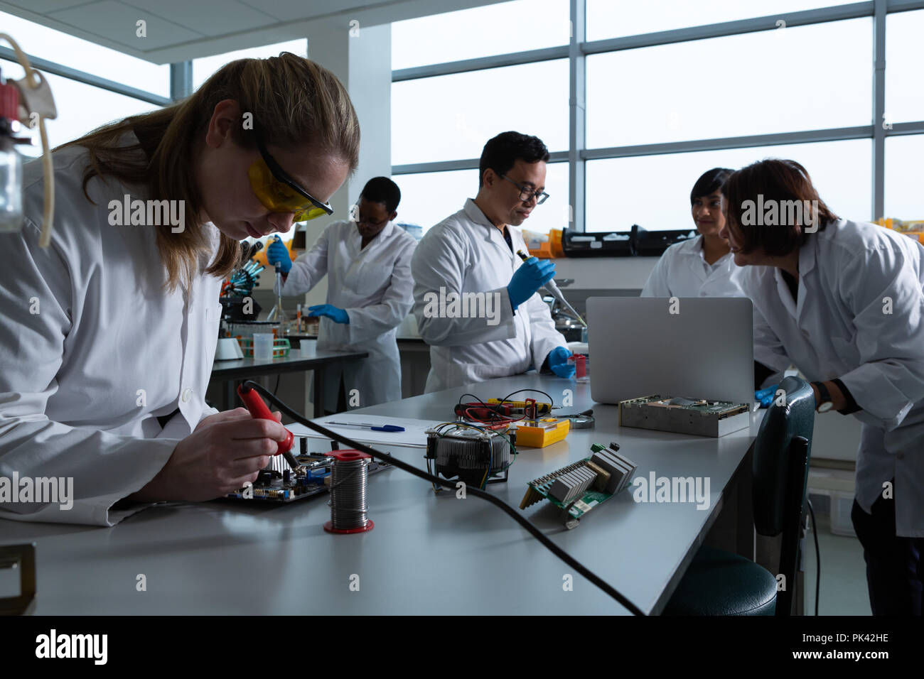 Female scientist soldering circuit board Stock Photo