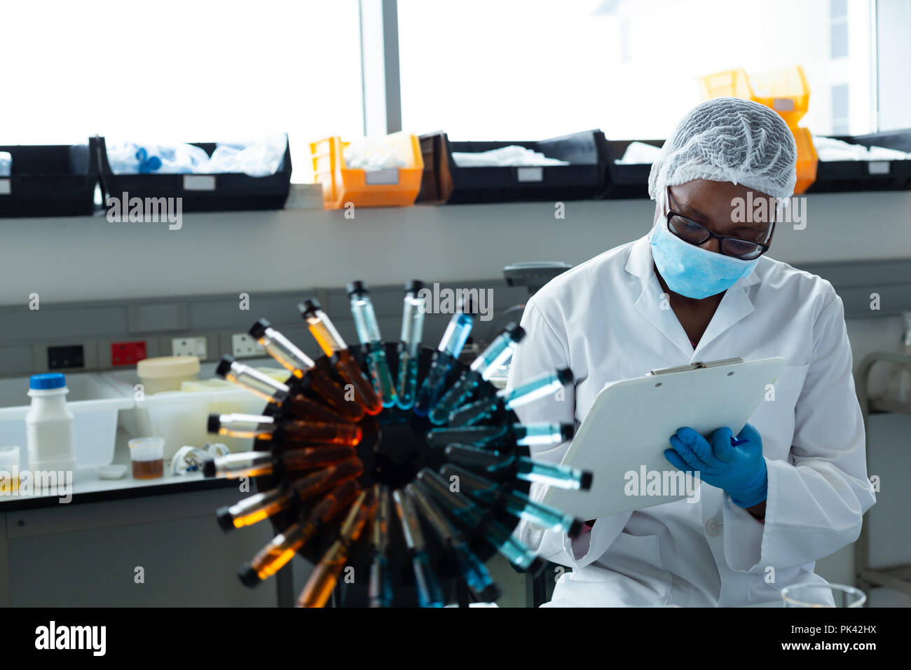 Female scientist writing on clipboard Stock Photo