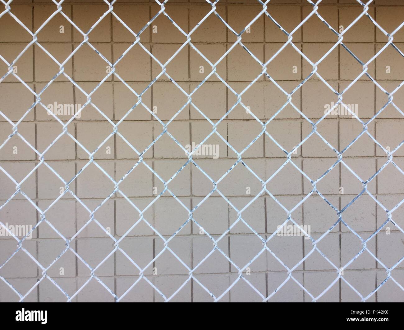 Square blocks white, behind chain link fencing. Stock Photo