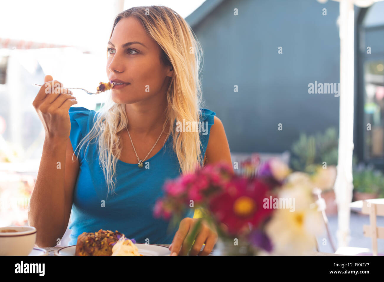 Woman having breakfast in outdoor cafe Stock Photo