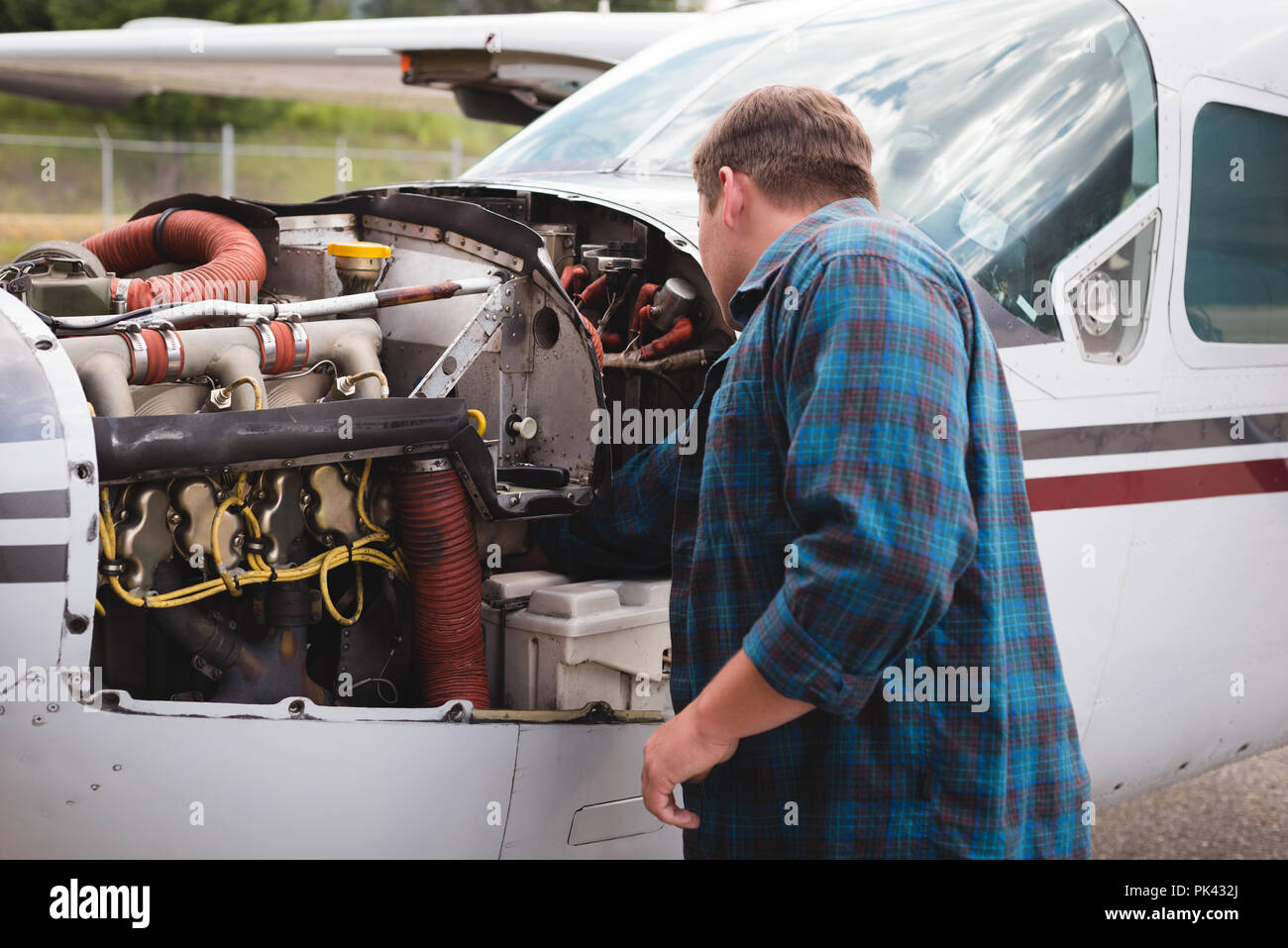 Engineer servicing aircraft engine near hangar Stock Photo