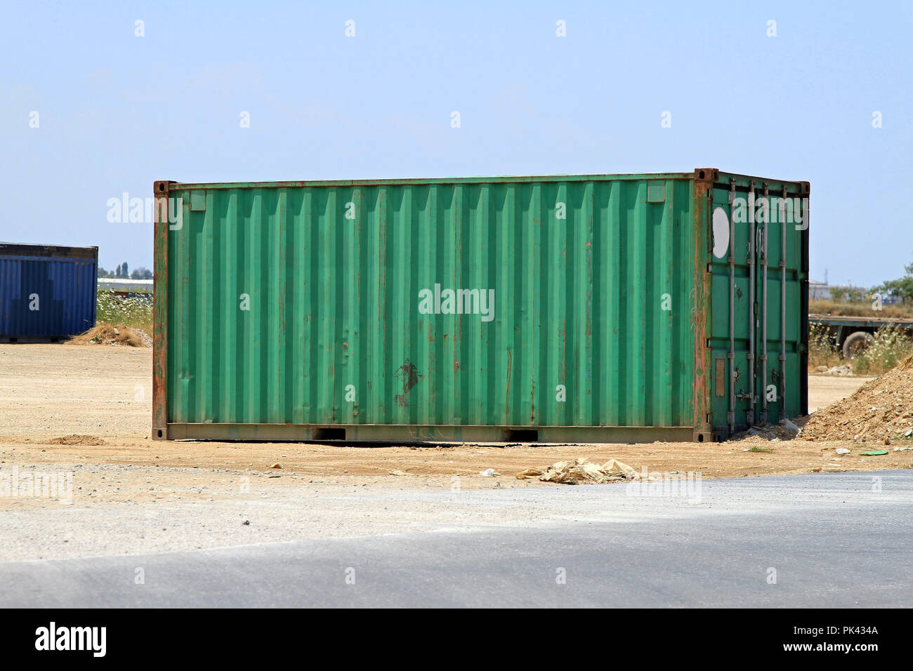 Green cargo shipping container in the field Stock Photo