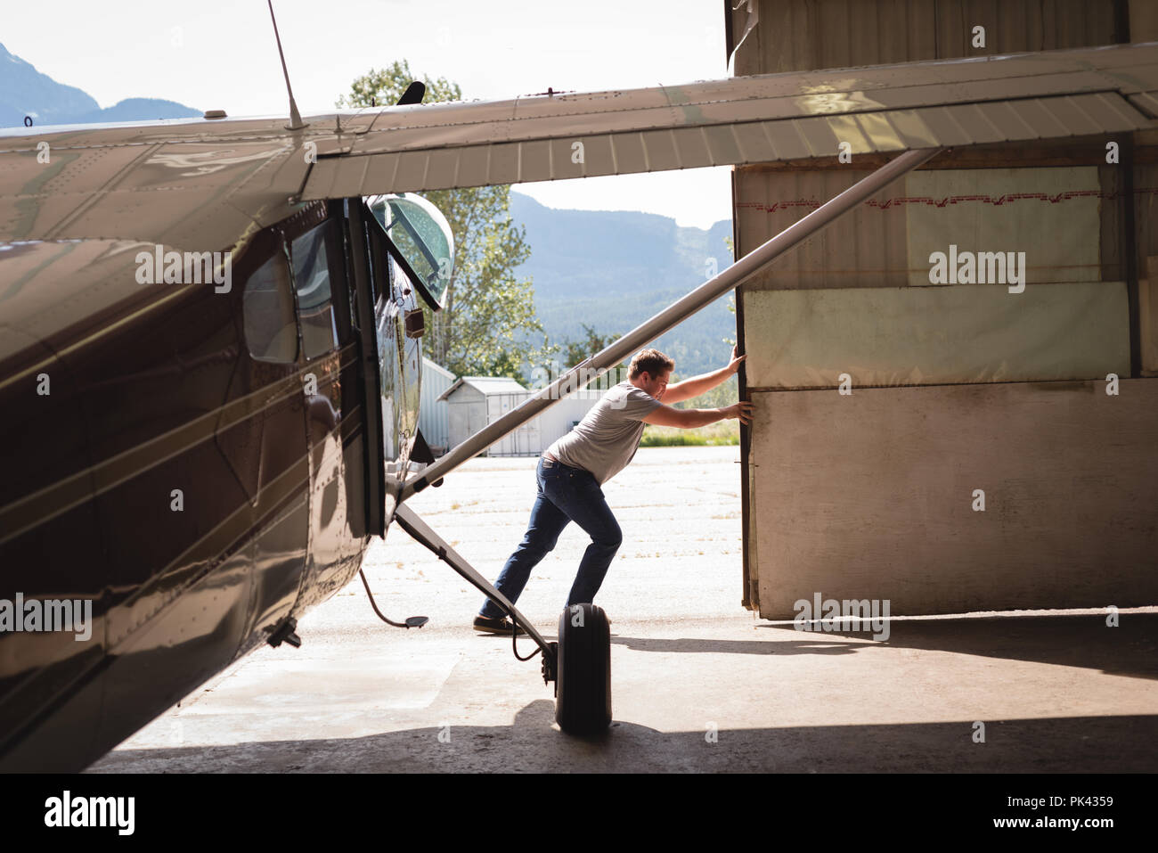 Mechanic opening hangar gate Stock Photo