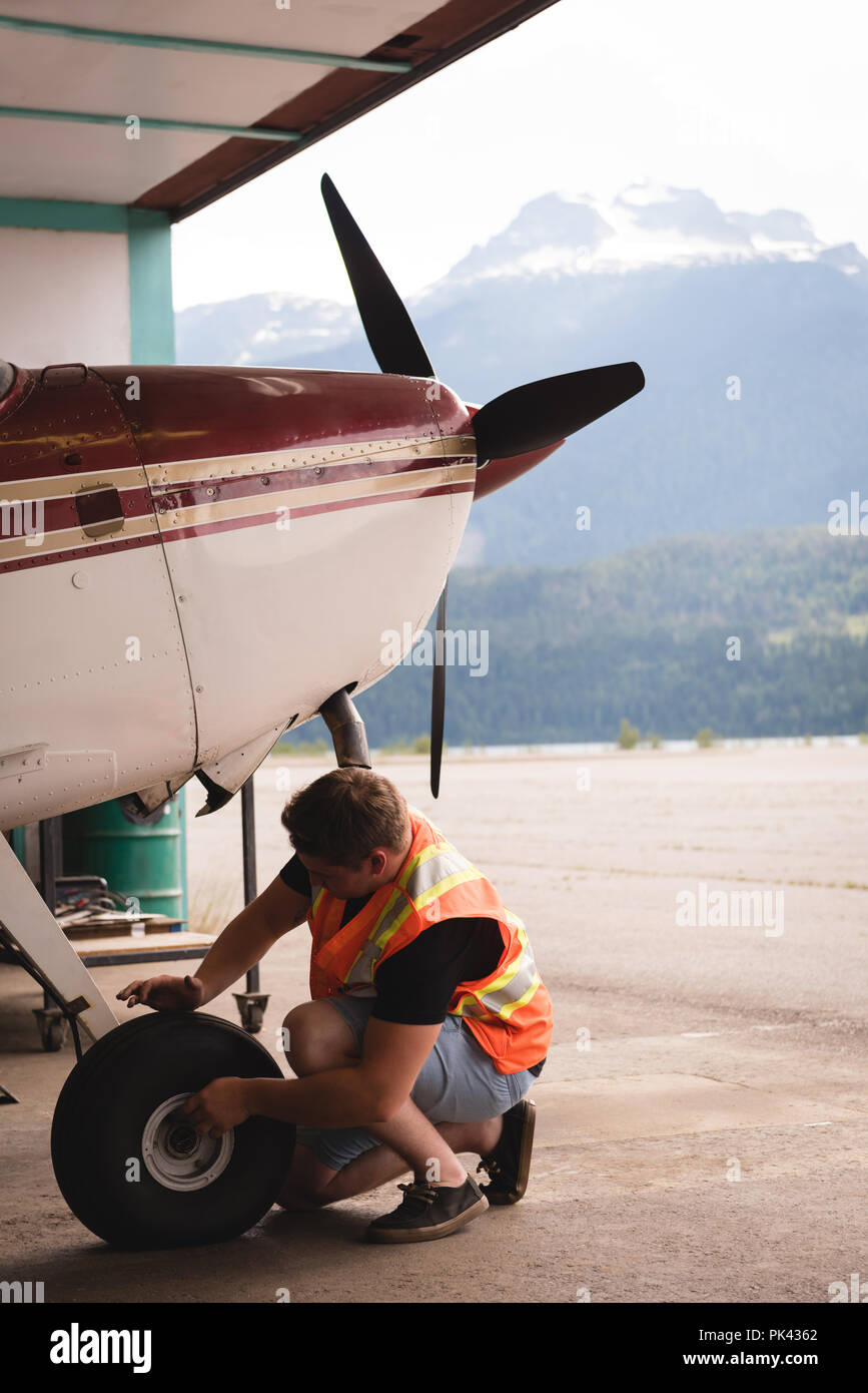 Mechanic servicing aircraft landing gear Stock Photo