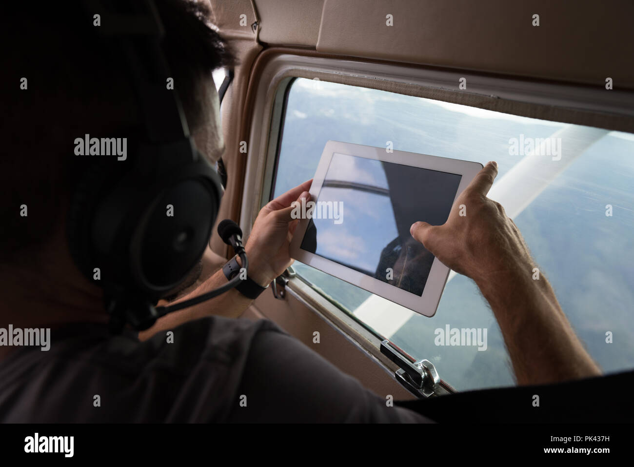 Pilot taking photos with digital table while flying Stock Photo Alamy