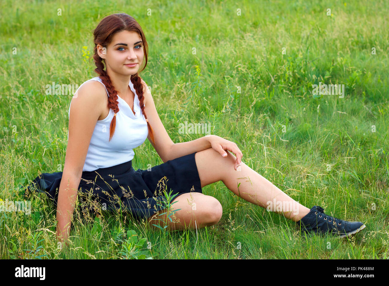 young girl sitting on green grass Stock Photo - Alamy