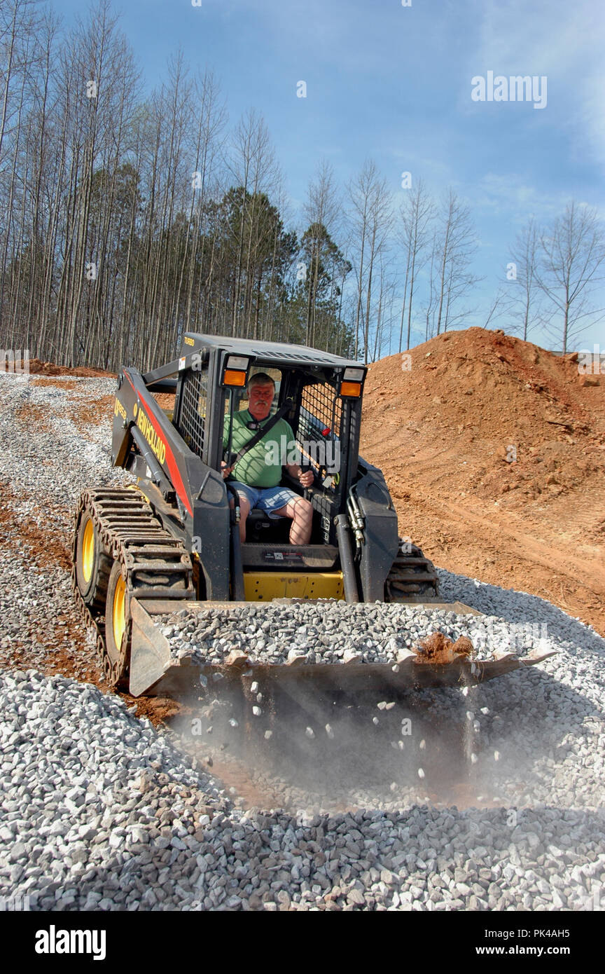 Leveling road way for driveway with stone and small bobcat in Georgia for building a one family home by building contractor on top of rock fill Stock Photo