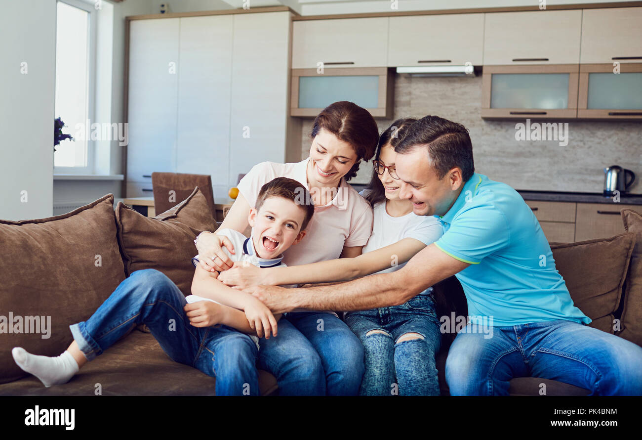 The family plays together fun on the couch. Stock Photo