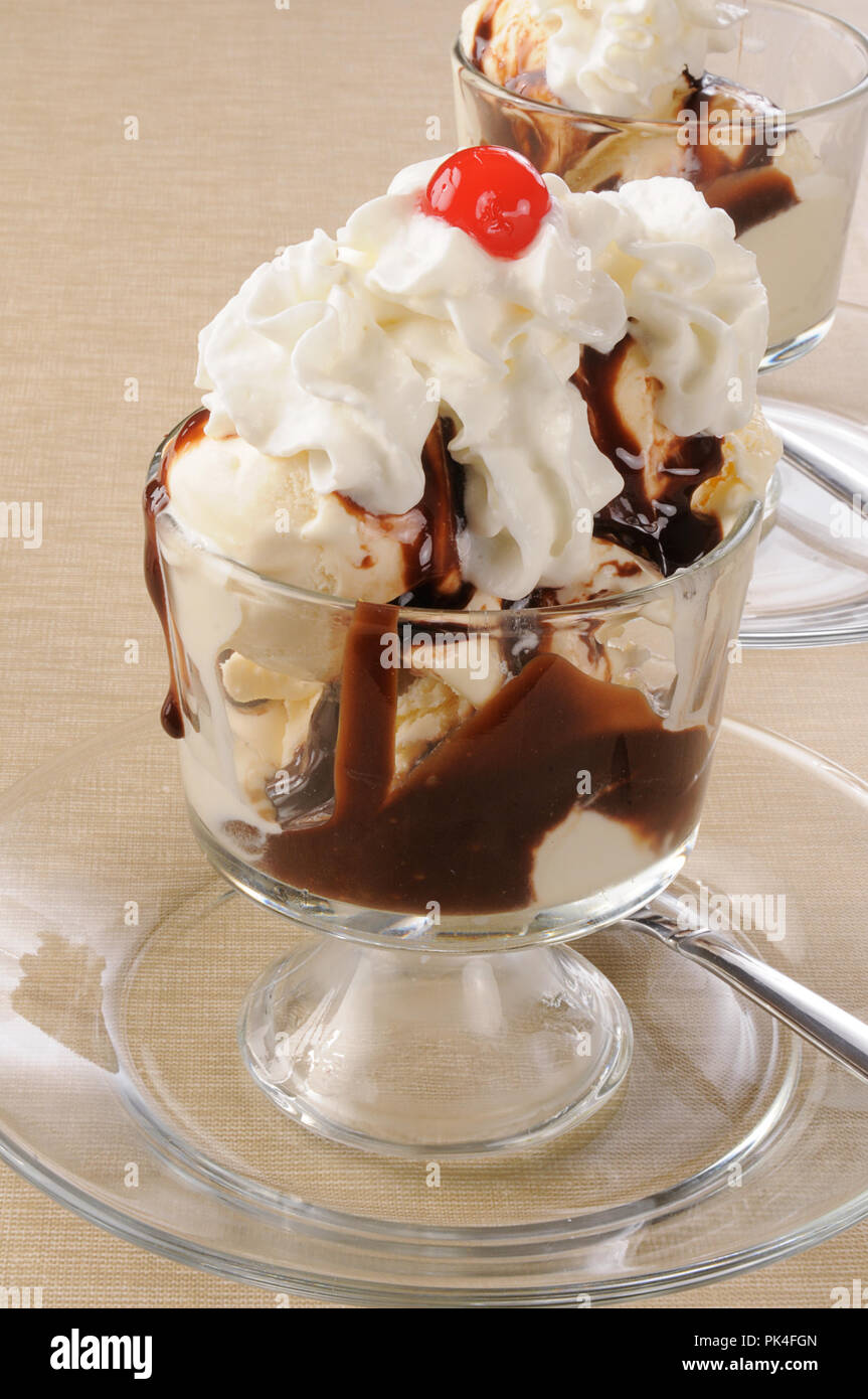 Vanilla ice cream topped iwth chocolate syrup and a maraschino cherry