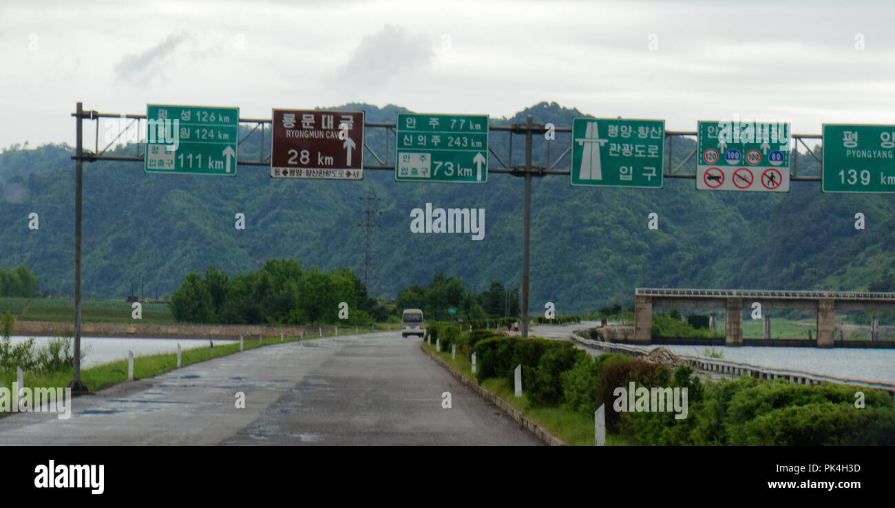 Multi language traffic signs over empty roads in North Korea Stock Photo