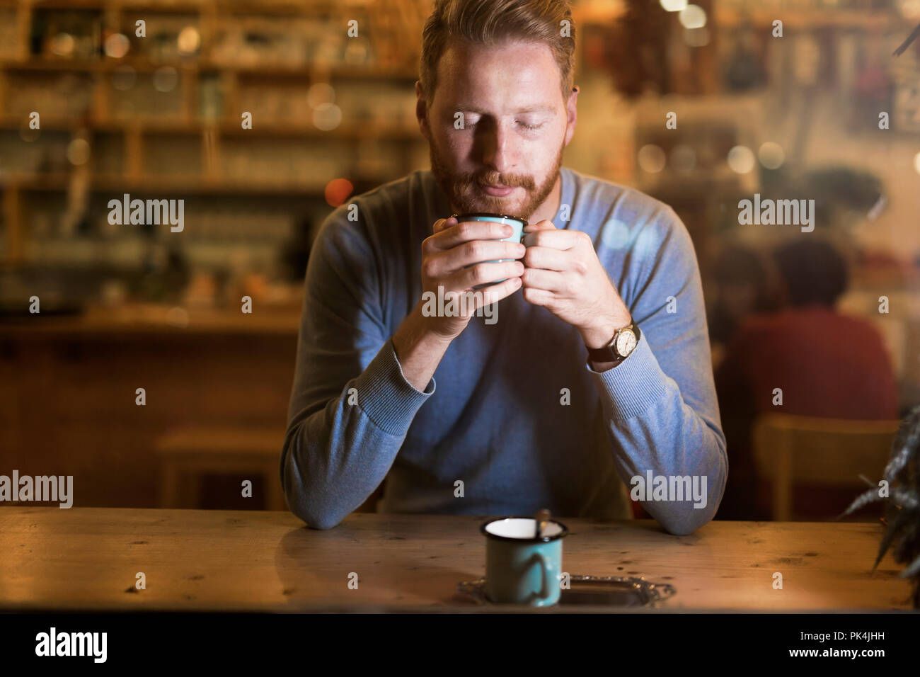 Young handsome man drinking coffee in bar Stock Photo