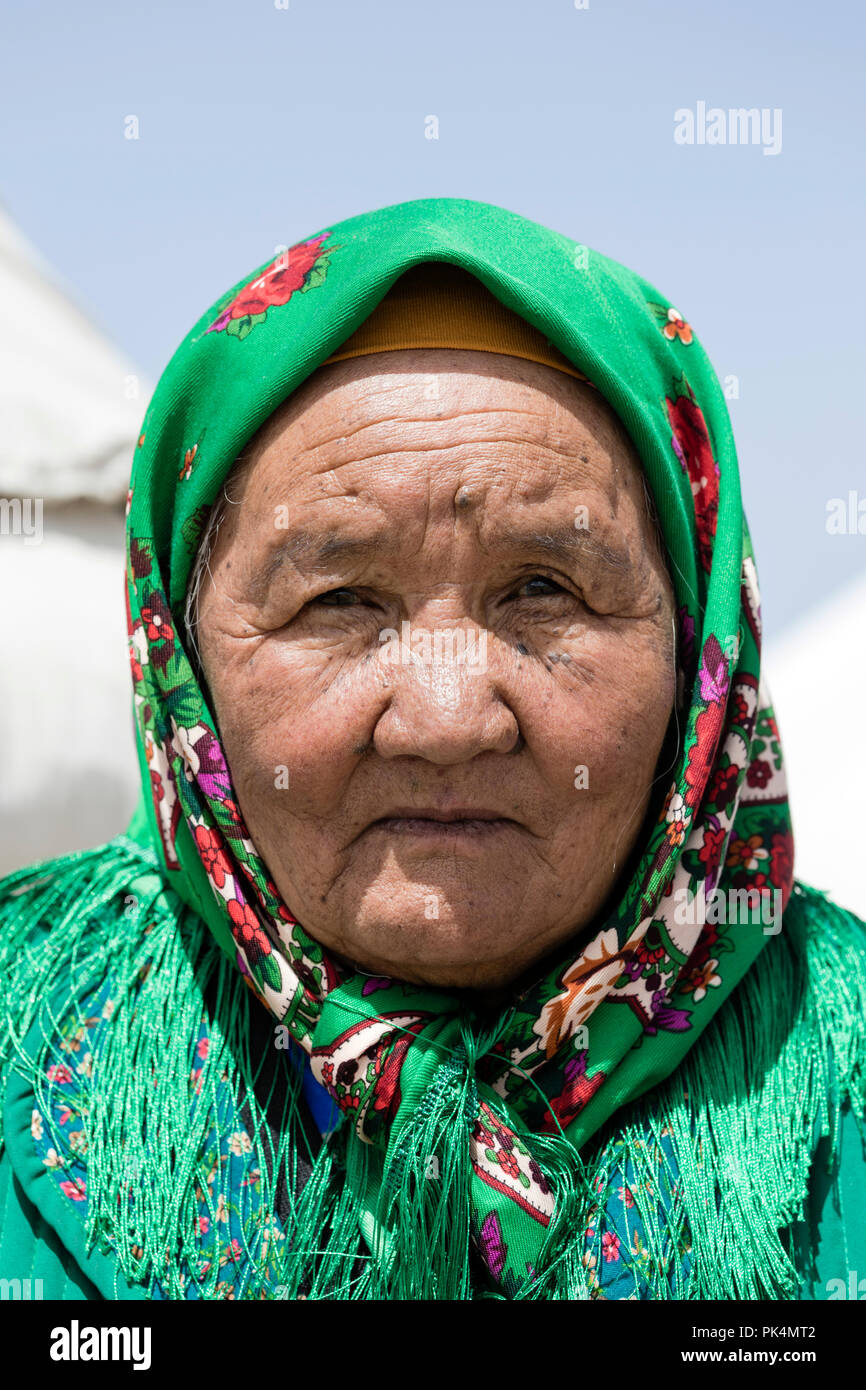 Song Kul, Kyrgyzstan, August 8 2018: Portrait of a beautiful Kyrgyz woman wearing a headscarf at Song Kul lake in Kyrgyzstan Stock Photo