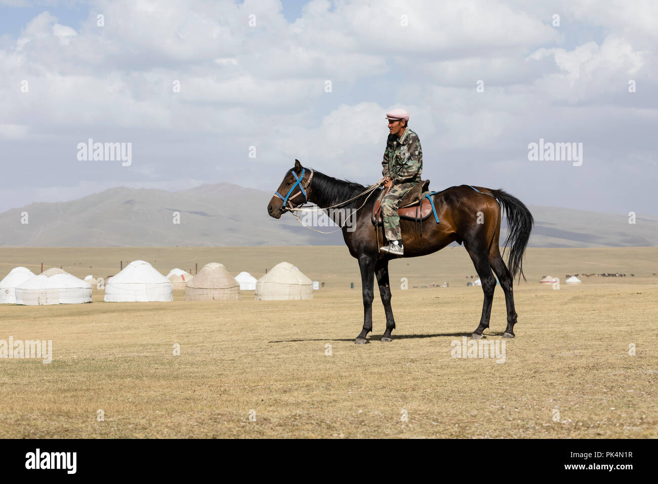 Song Kul, Kyrgyzstan, August 8 2018: A Kyrgyz sits on a horse at Song Kul Lake in Kyrgyzstan Stock Photo