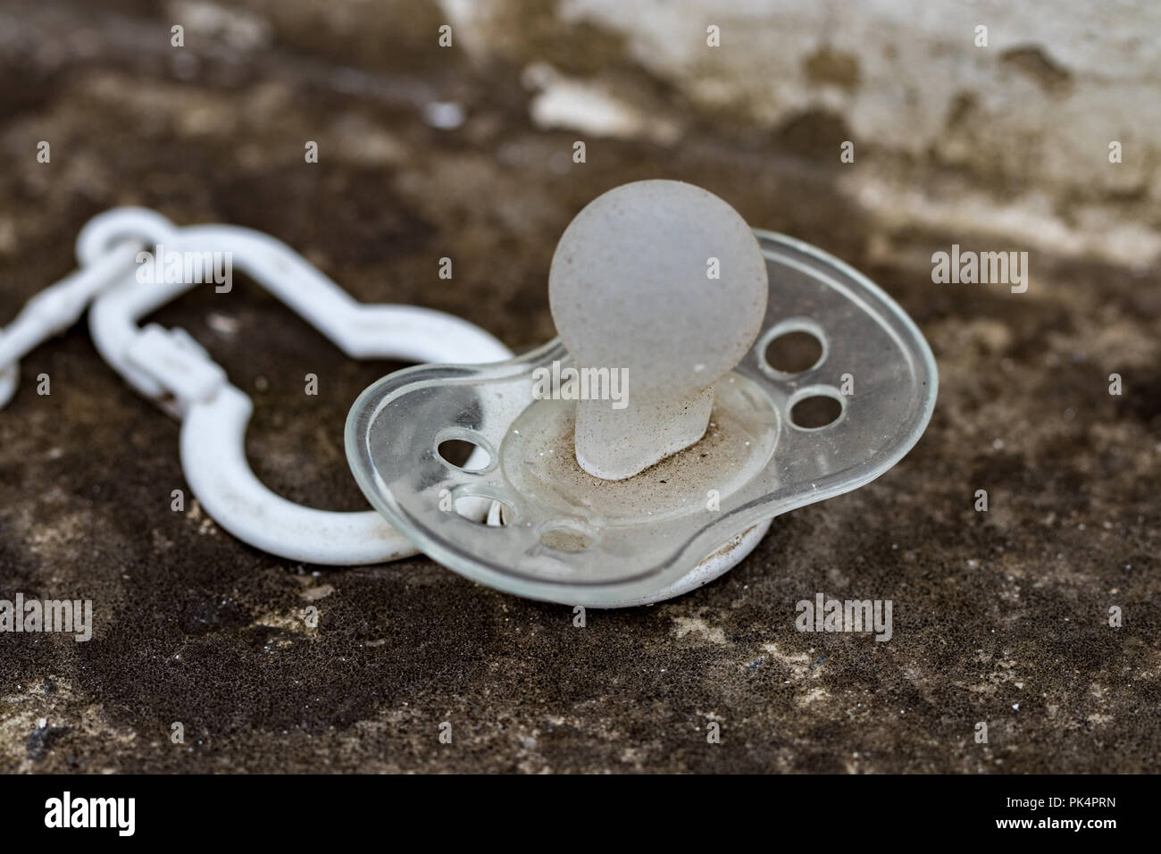 dirty silicone pacifier lying on the ground Stock Photo - Alamy