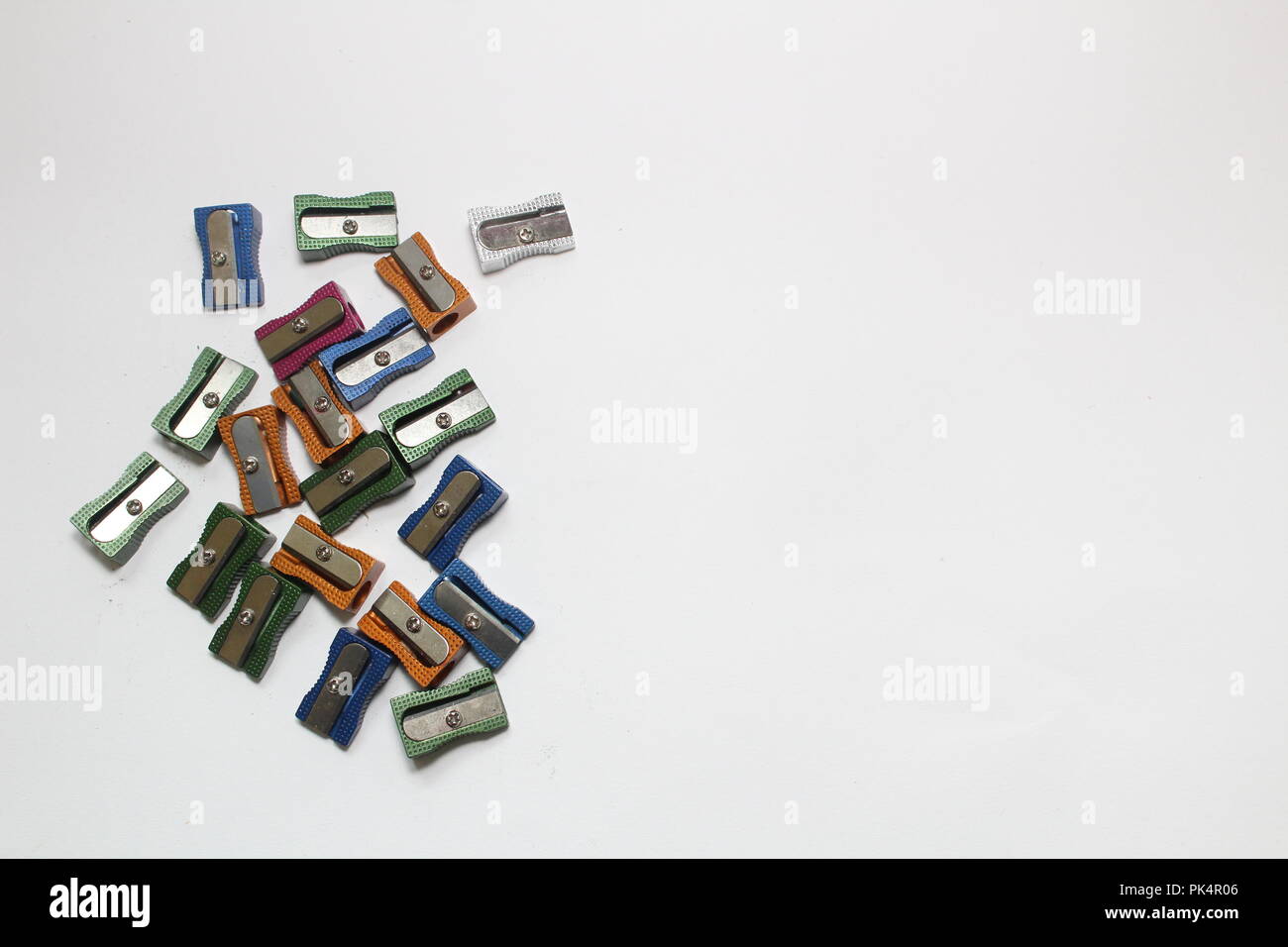 Multi coloured metal pencil sharpeners on plain background, a still life study Stock Photo