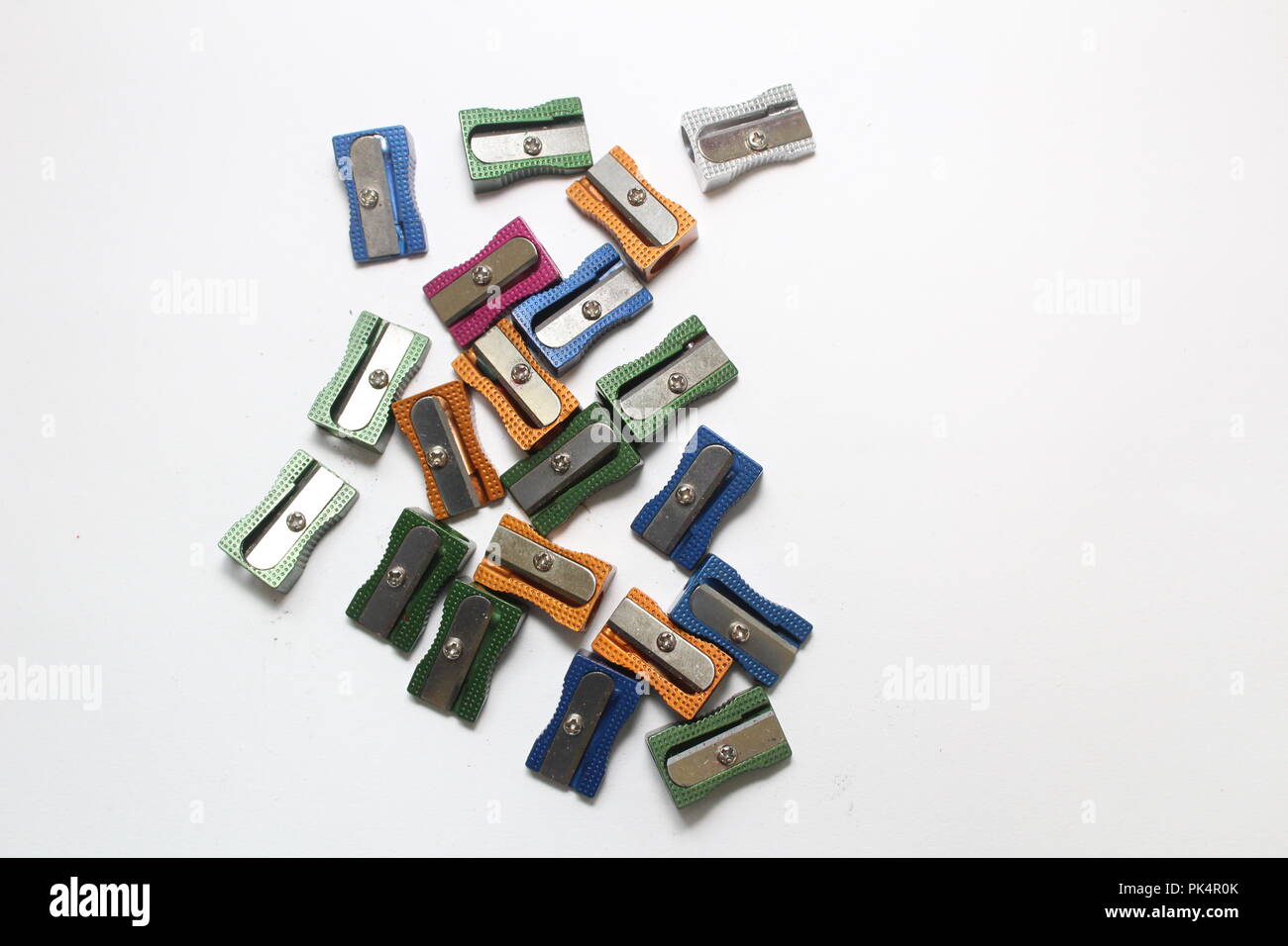 Multi coloured metal pencil sharpeners on plain background, a still life study Stock Photo