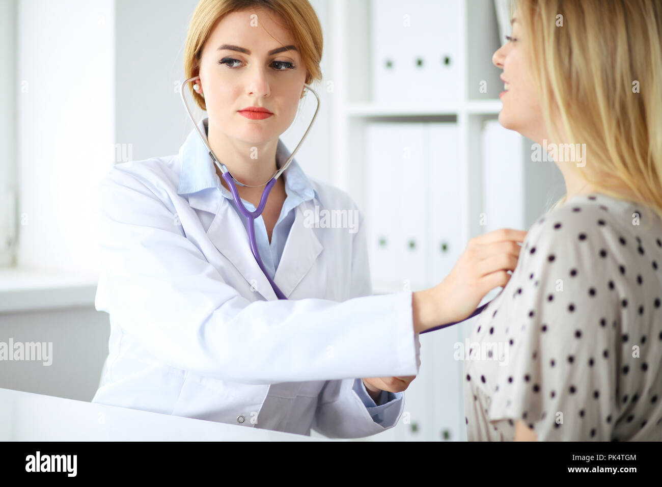 Doctor examines a patient with a stethoscope Stock Photo - Alamy