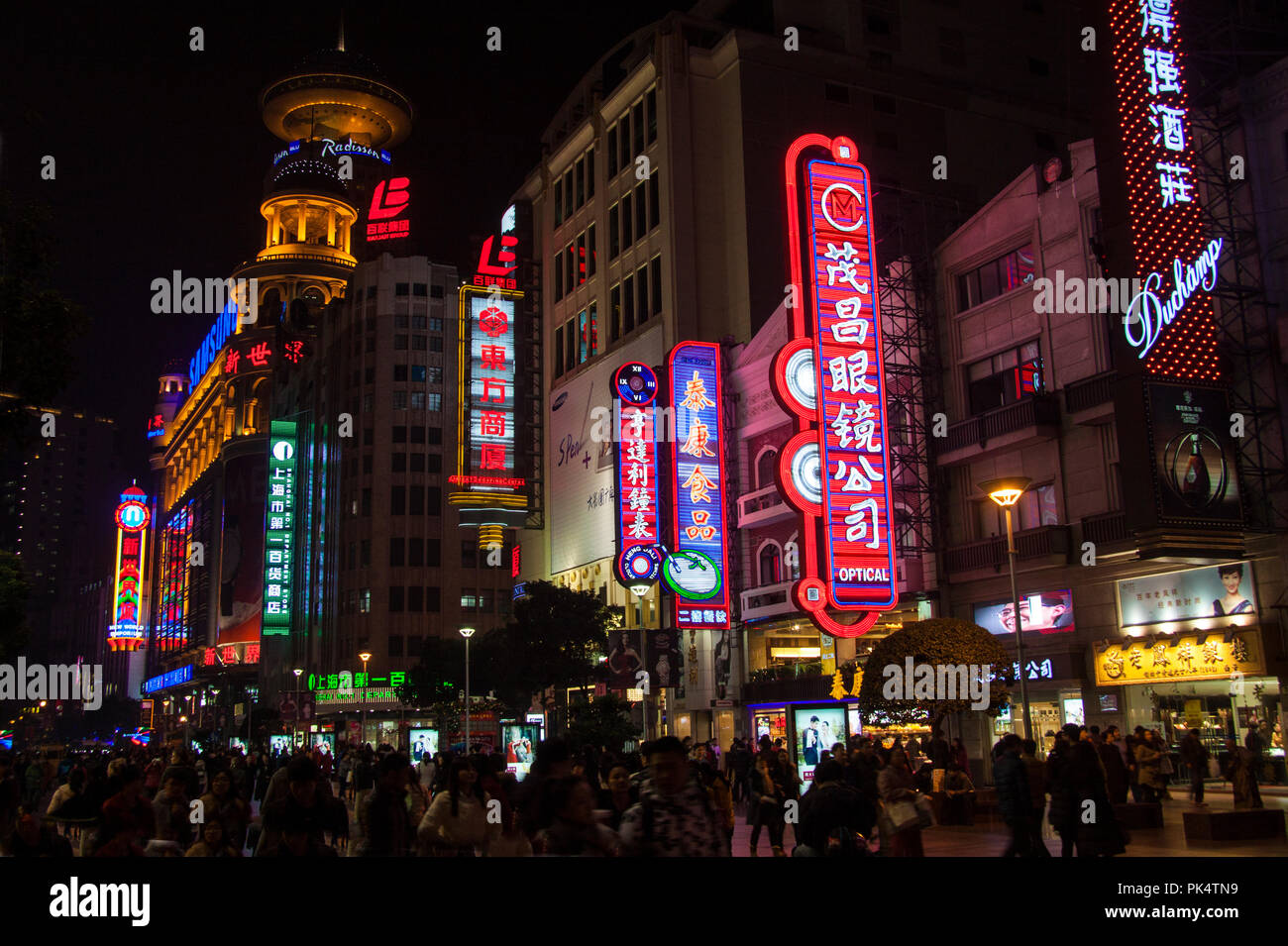 Shanghai, China - December 12, 2014: Neon signs and shops and people at night along Nanjing Road, Shanghai's premier shopping street Stock Photo