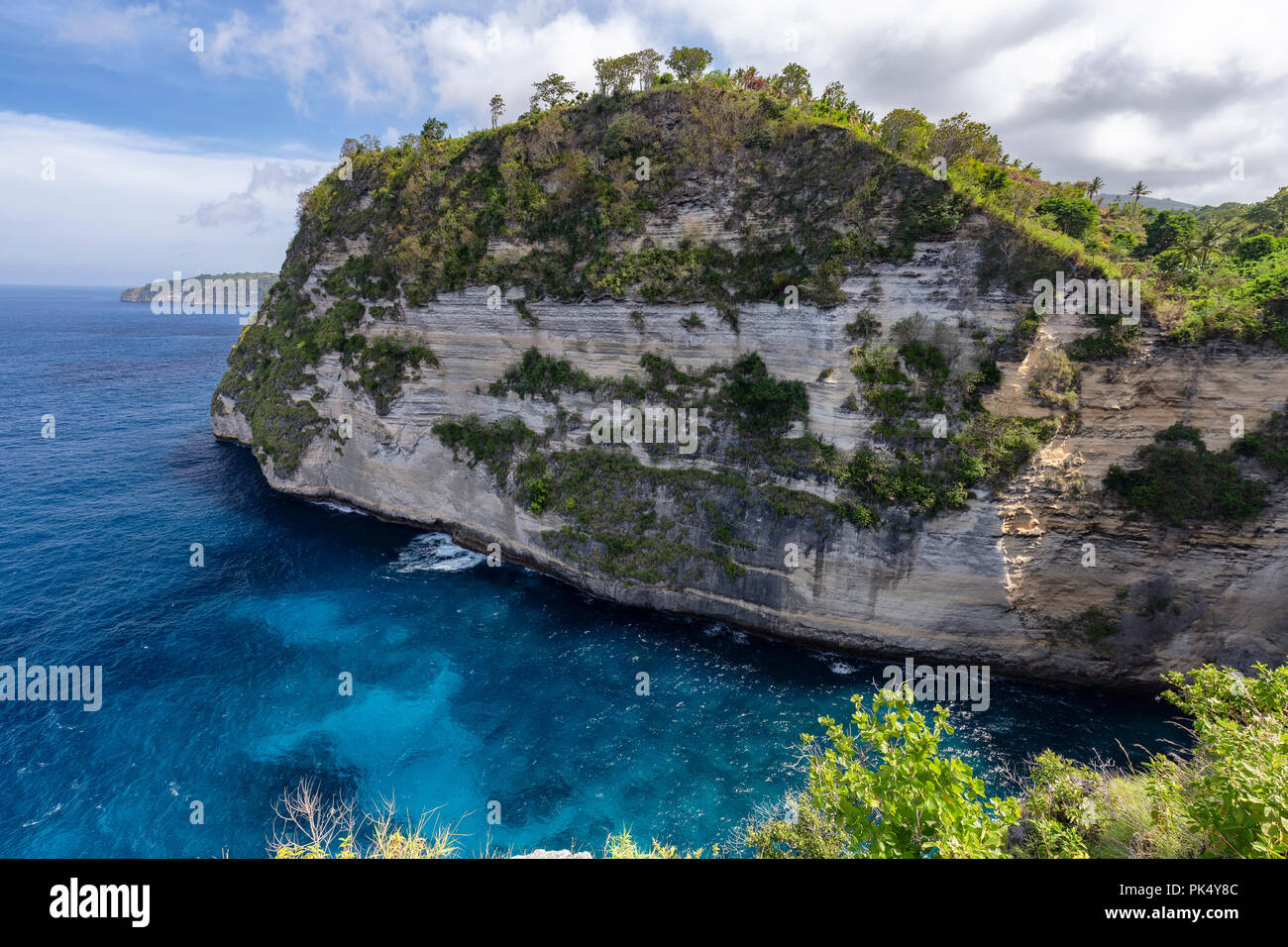 The cliff and beautiful blue clear water below the Belah Poh point, a popular place to watch the sunrise on Nusa Penida. Stock Photo