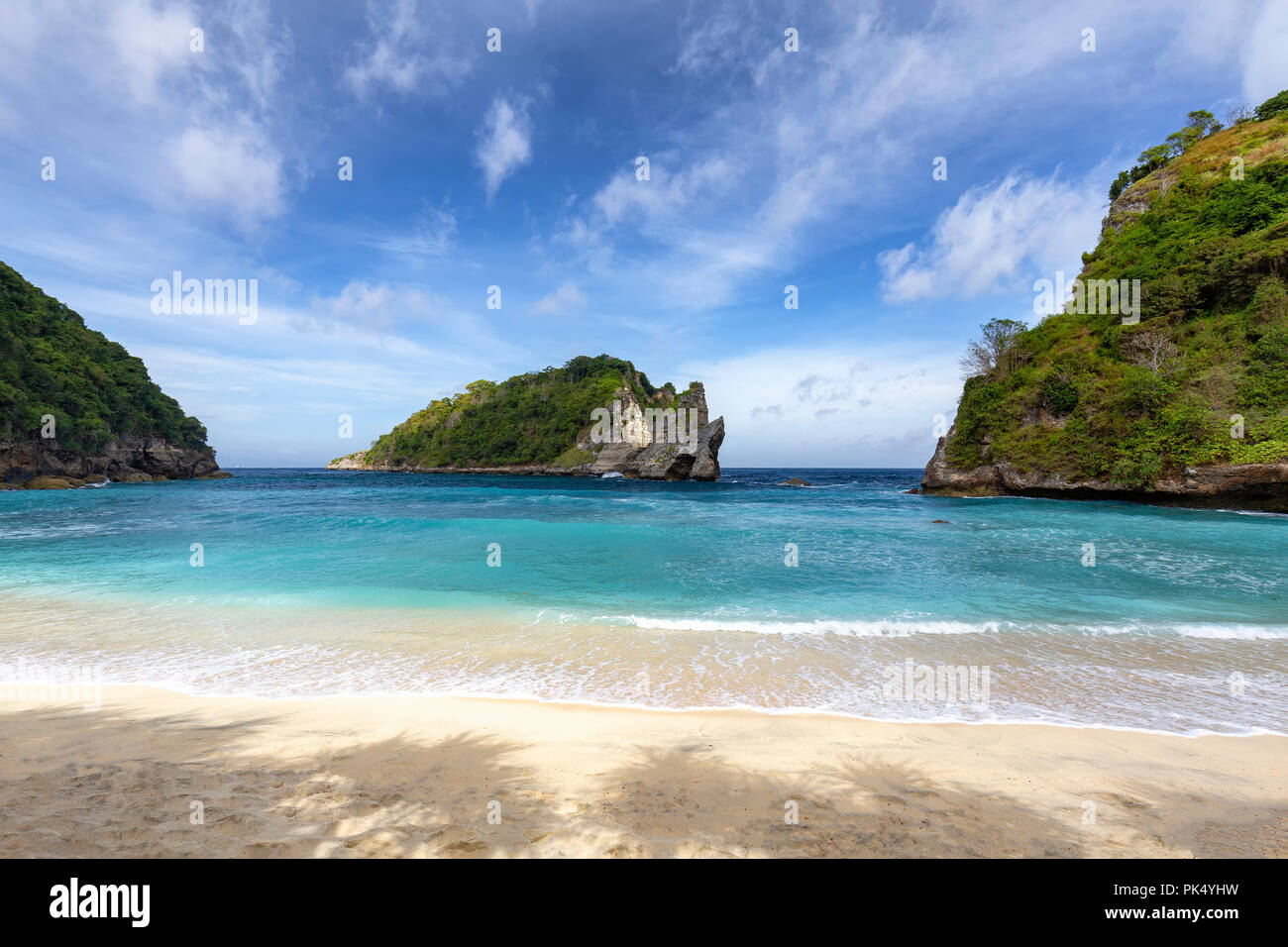 Shade and calm surf at Atuh Beach, a popular tourist area of Nusa Penida. Stock Photo