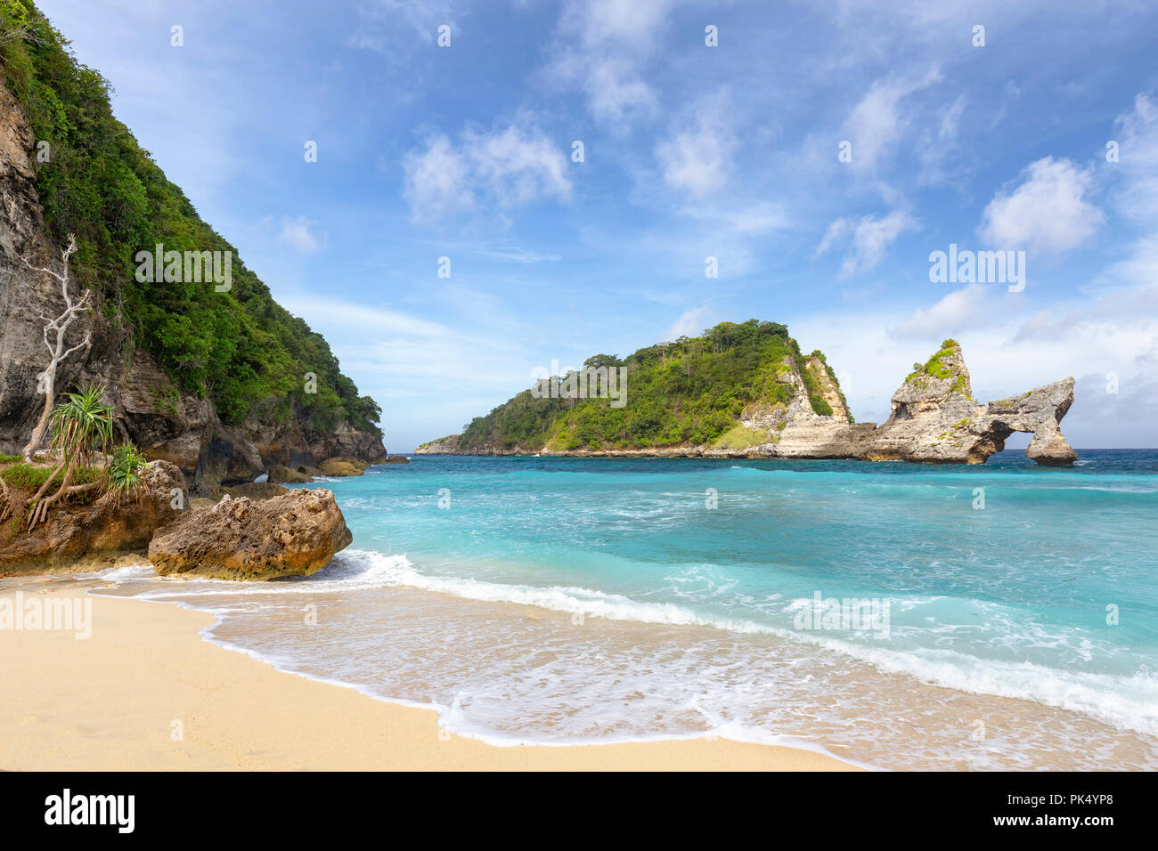 Beautiful afternoon view of an amazing arch on a small island just off of Atuh Beach in Nusa Penida. Stock Photo