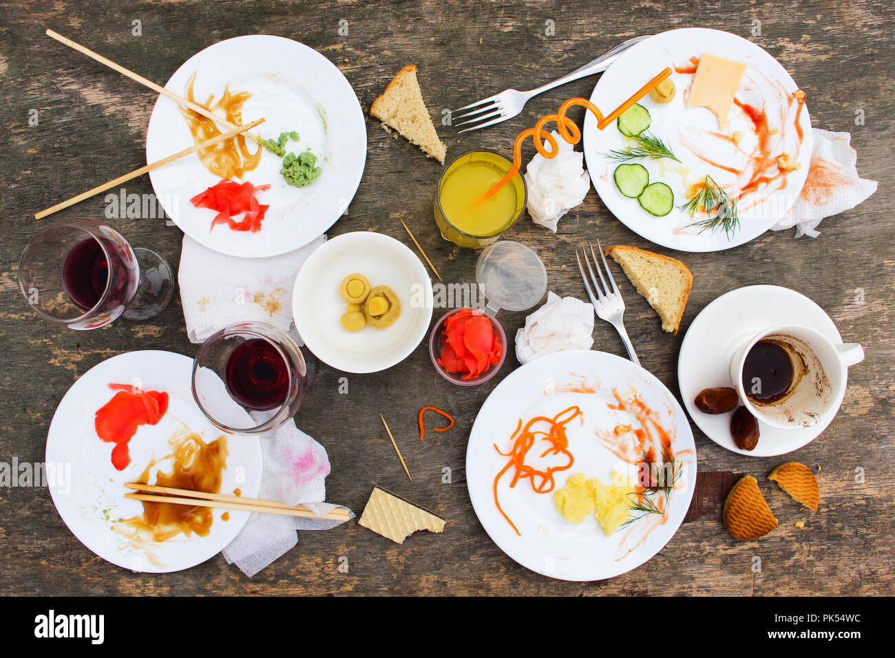 Messy table after party. Leftover food, spilled drinks, dirty dishes. Stock Photo