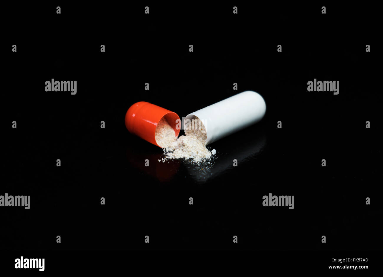 Pill split in half isolated on a black background. Prescription medicine for a hospital patient