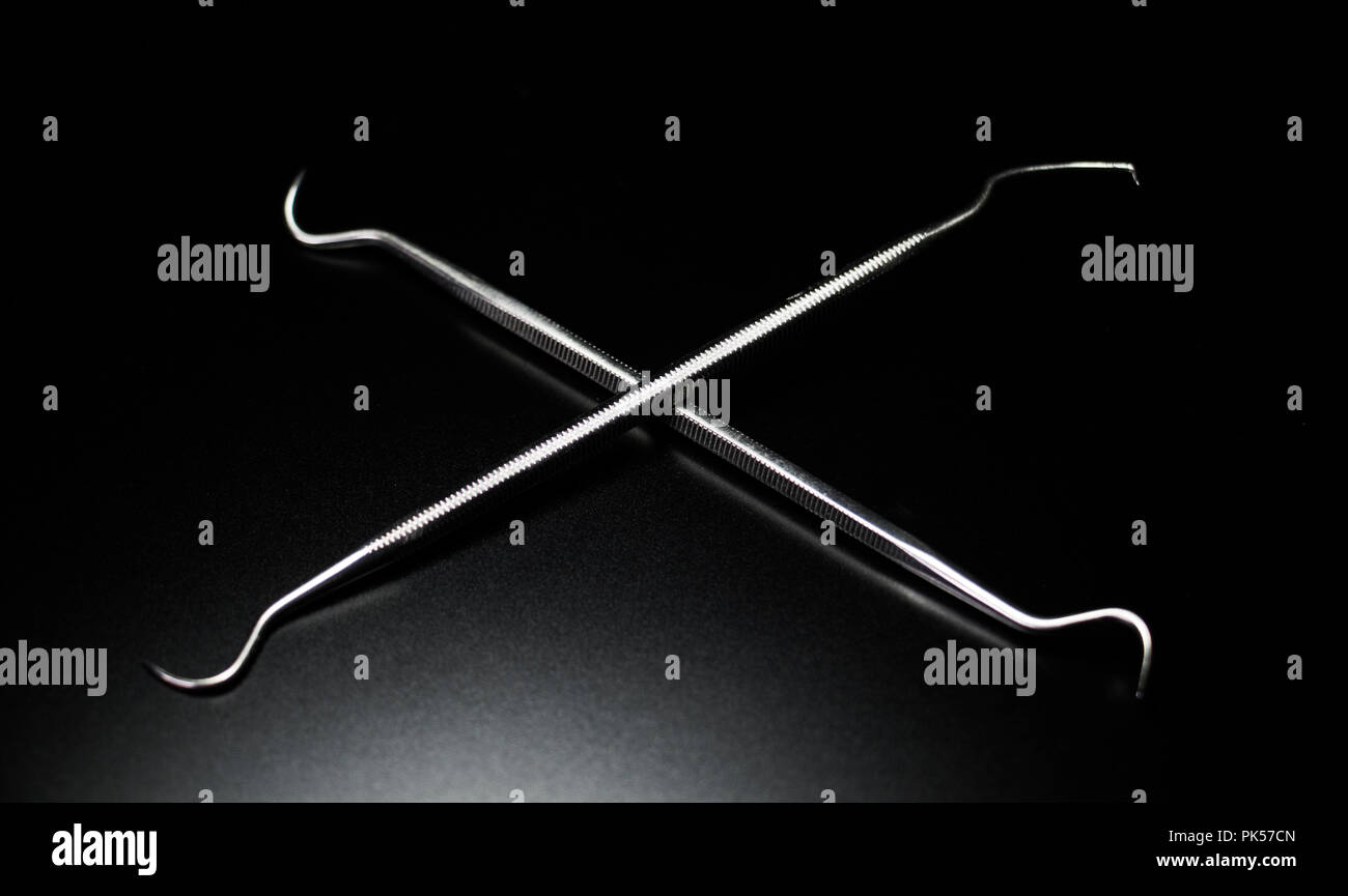 Plaque removal. X pattern of two dental picks. Stainless steel dentist