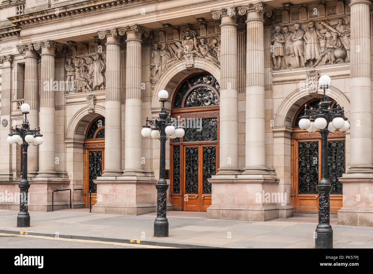 Glasgow, Scotland, UK - June 17, 2012: Entrance to Brown stone Glasgow City Chambers building shows brown doors and frescoes. Street light in front. Stock Photo