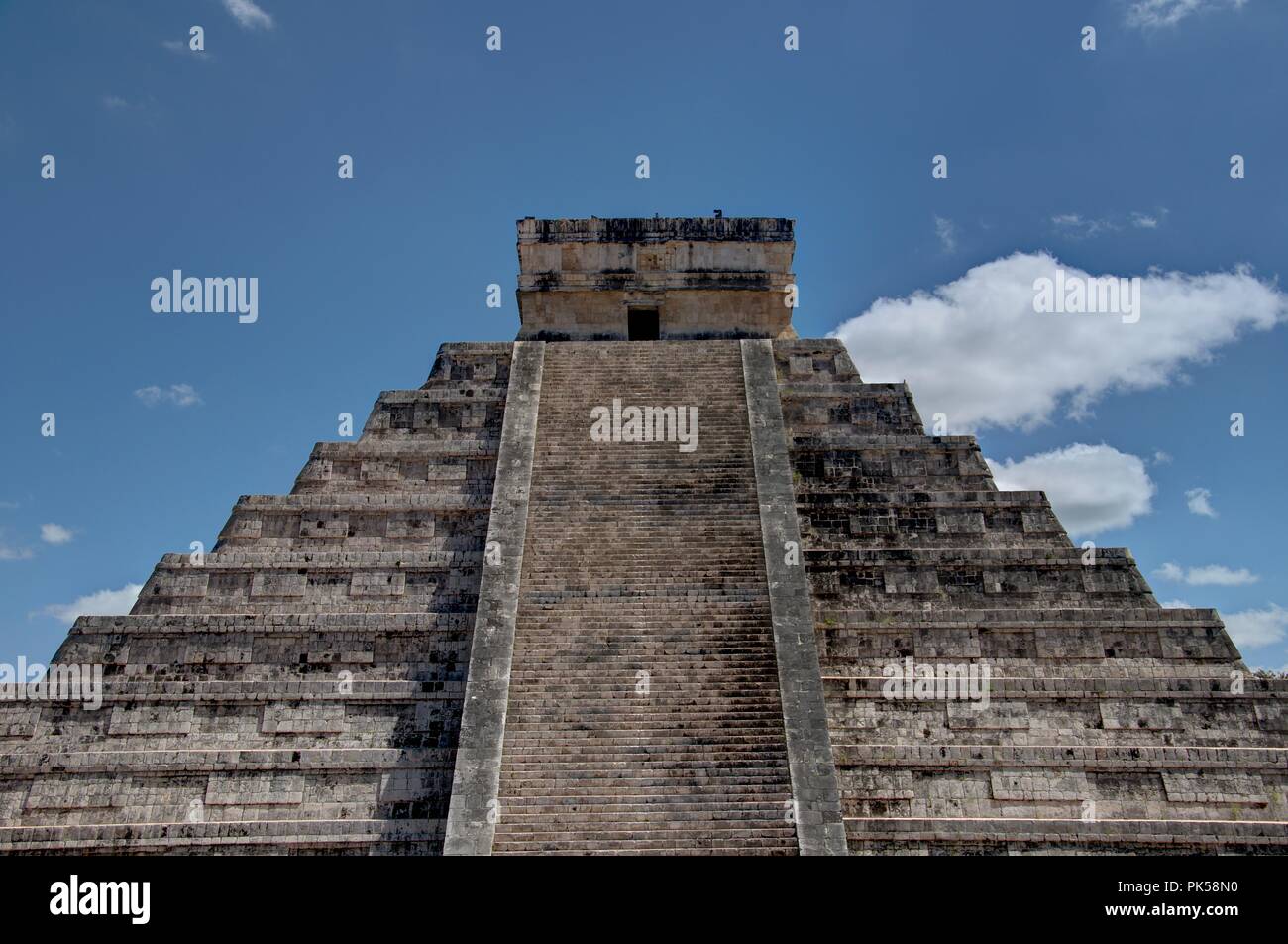 Ancient Castle made out of stone. Mayan palace with a blue sky background. El Castillo heritage site. Stock Photo