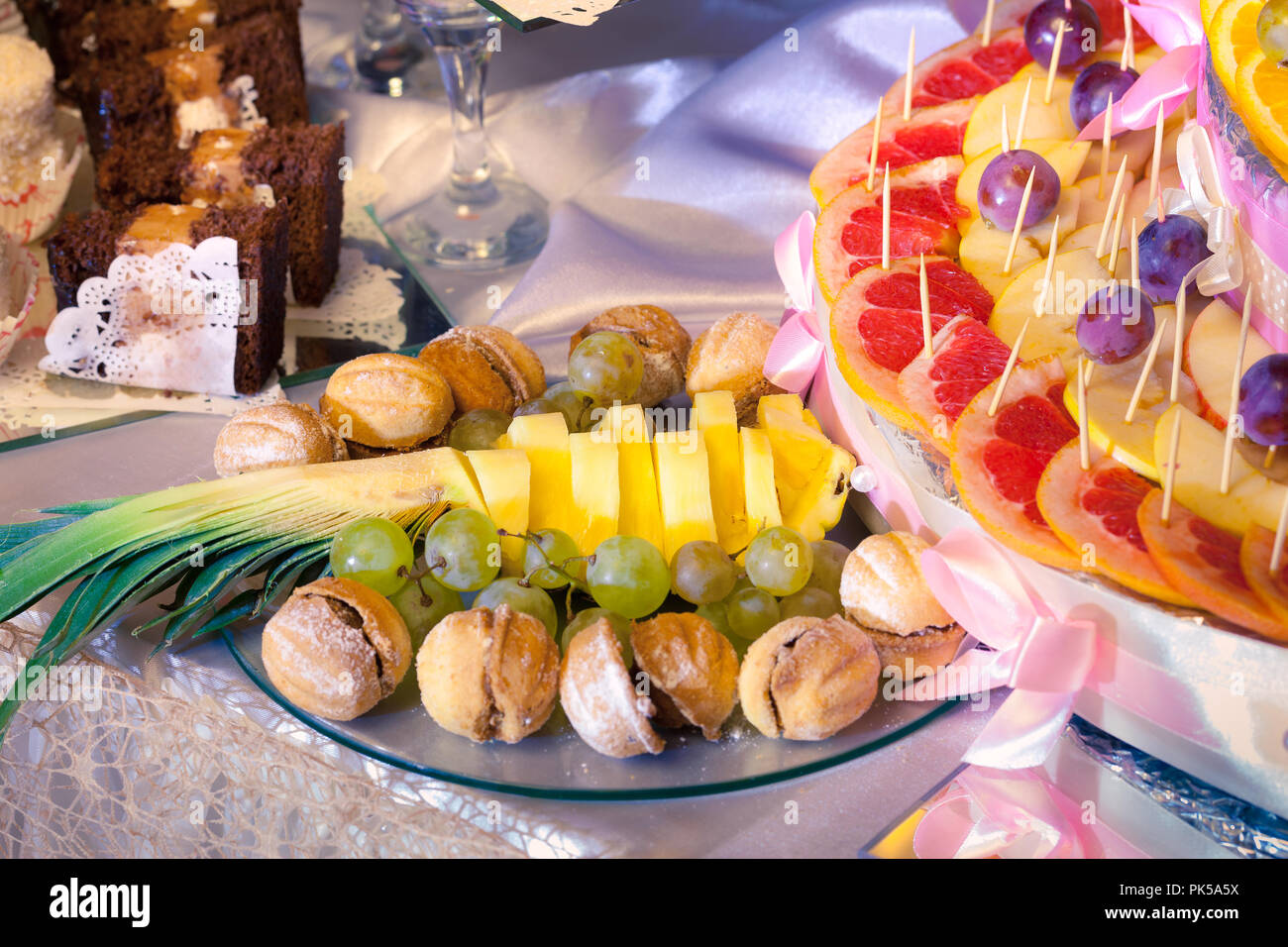 Sliced fruits and sweets for wedding table Stock Photo