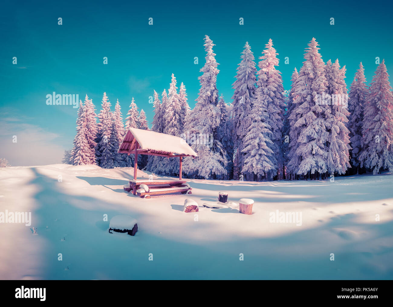 Resting place with alcove in the snowy mountain forest in sunny morning. Instagram toning Stock Photo