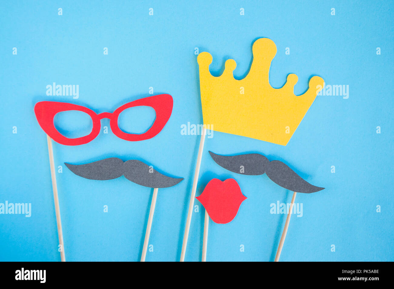 Colorful photo booth props glasses, lips, crown and moustaches on pink background. Set of party props. Stock Photo