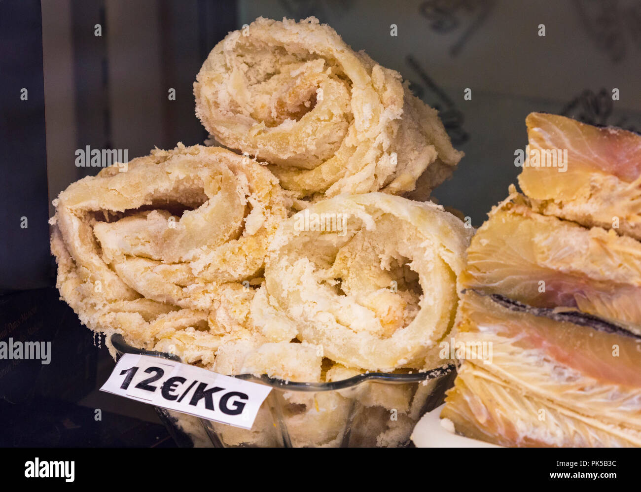 Rolls of dried codfish in Spanish shop window. The salted cod is known as bacalao in Spanish. Stock Photo