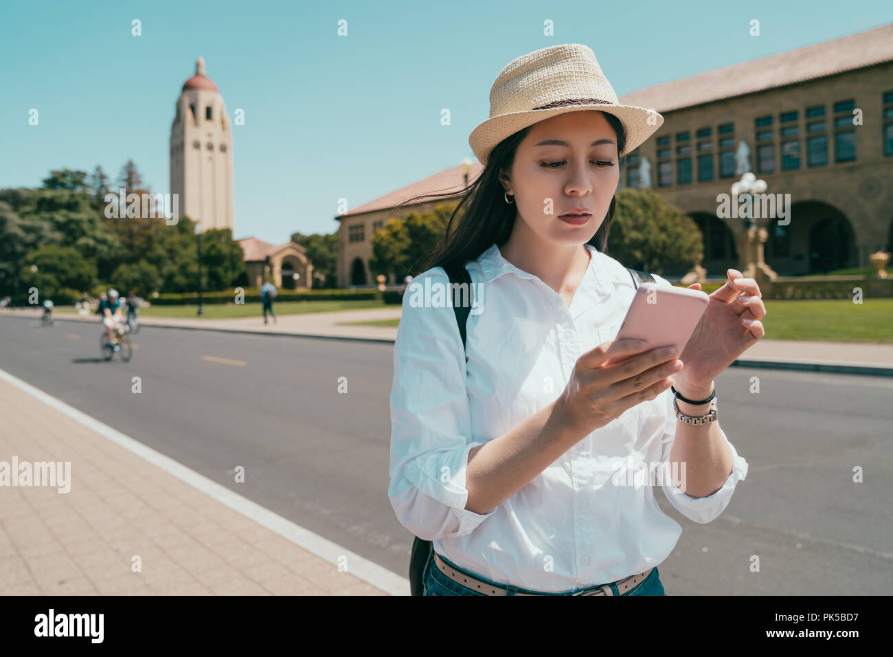 stylish woman using a smartphone and looking lost for not sure where she is going to. Stock Photo