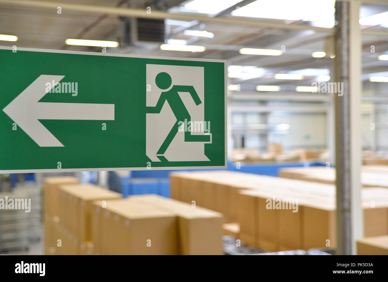 emergency exit sign in the warehouse of an industrial company Stock Photo