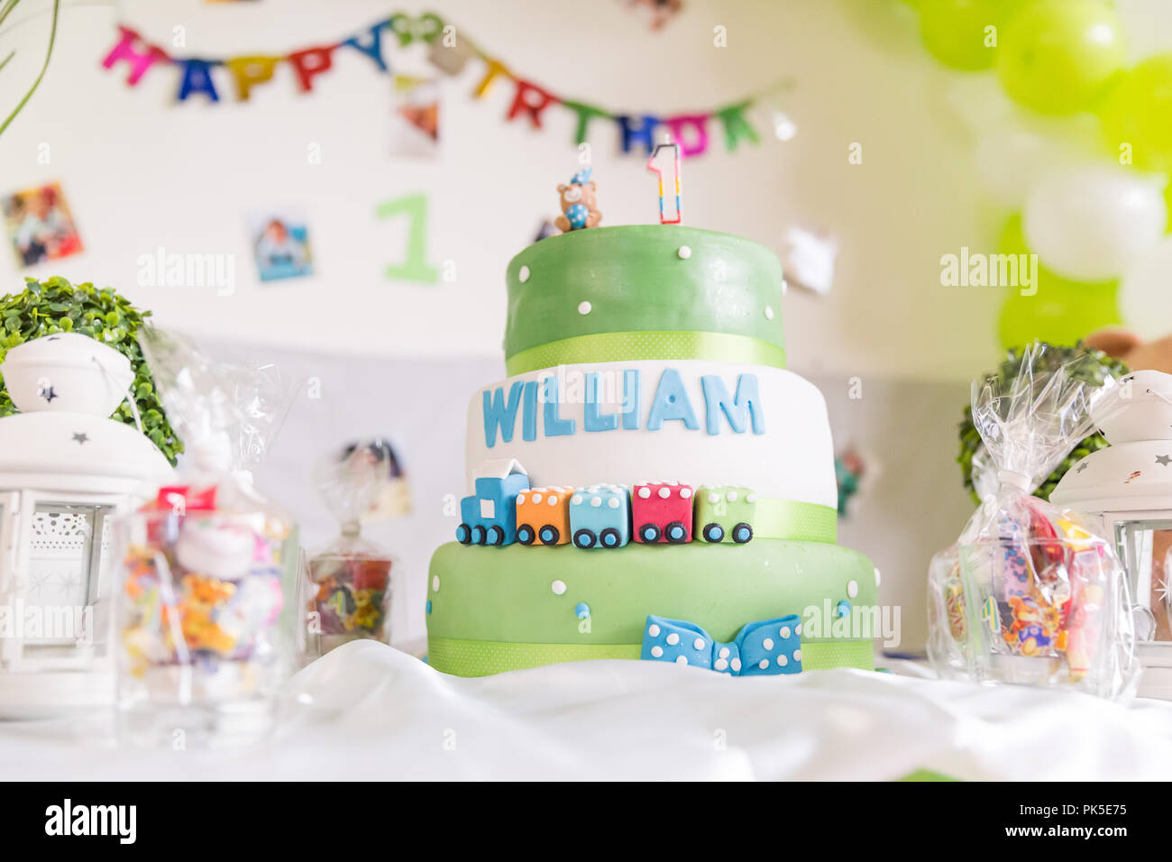 Green and White Birthday Cake with One Year Old Candle with Happy Birthday  Banner in the Background Stock Photo - Alamy