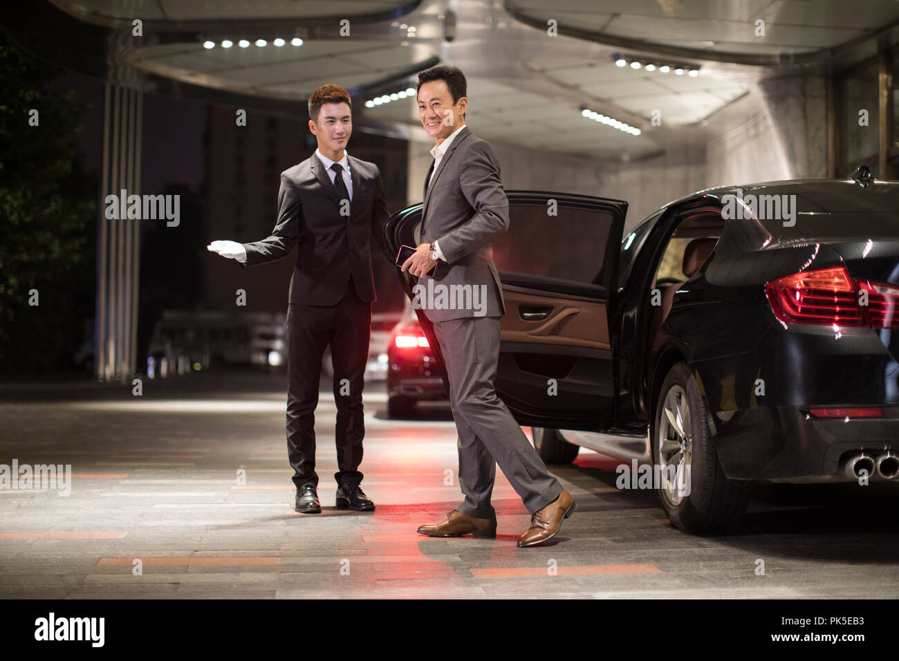 Chauffeur opening car door for passenger Stock Photo Alamy