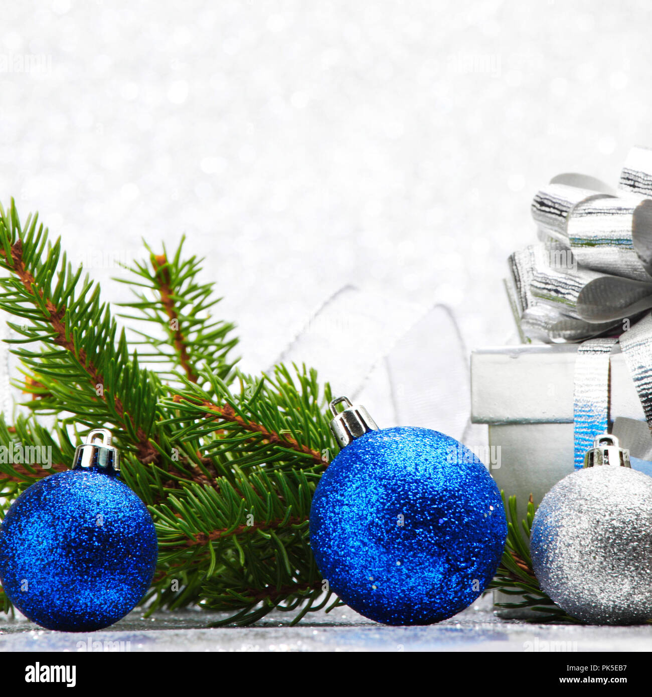 Christmas fir tree branch and decoration on silver glitter background ...