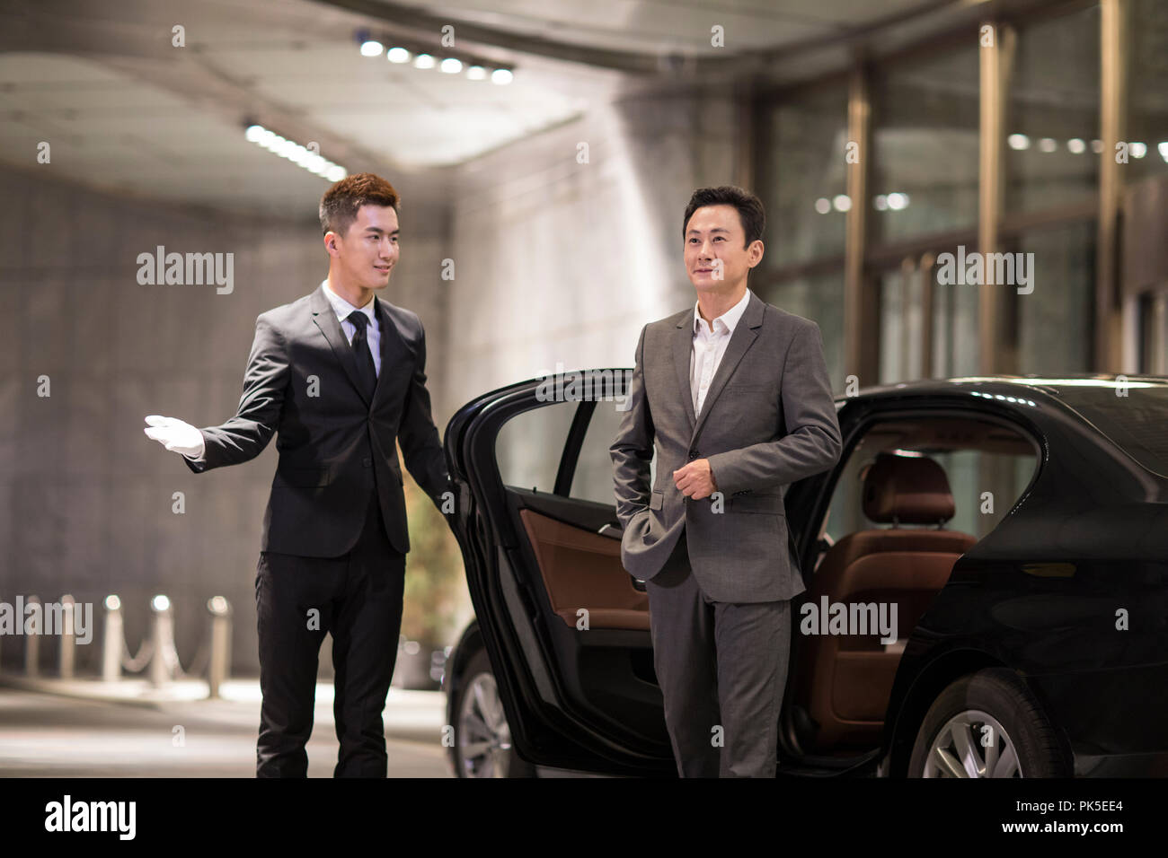 Chauffeur opening car door for passenger Stock Photo Alamy