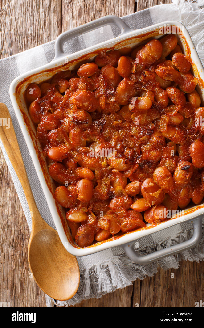Serbian food: prebranac baked beans with onion close-up in baking dish on a table. Vertical top view from above Stock Photo