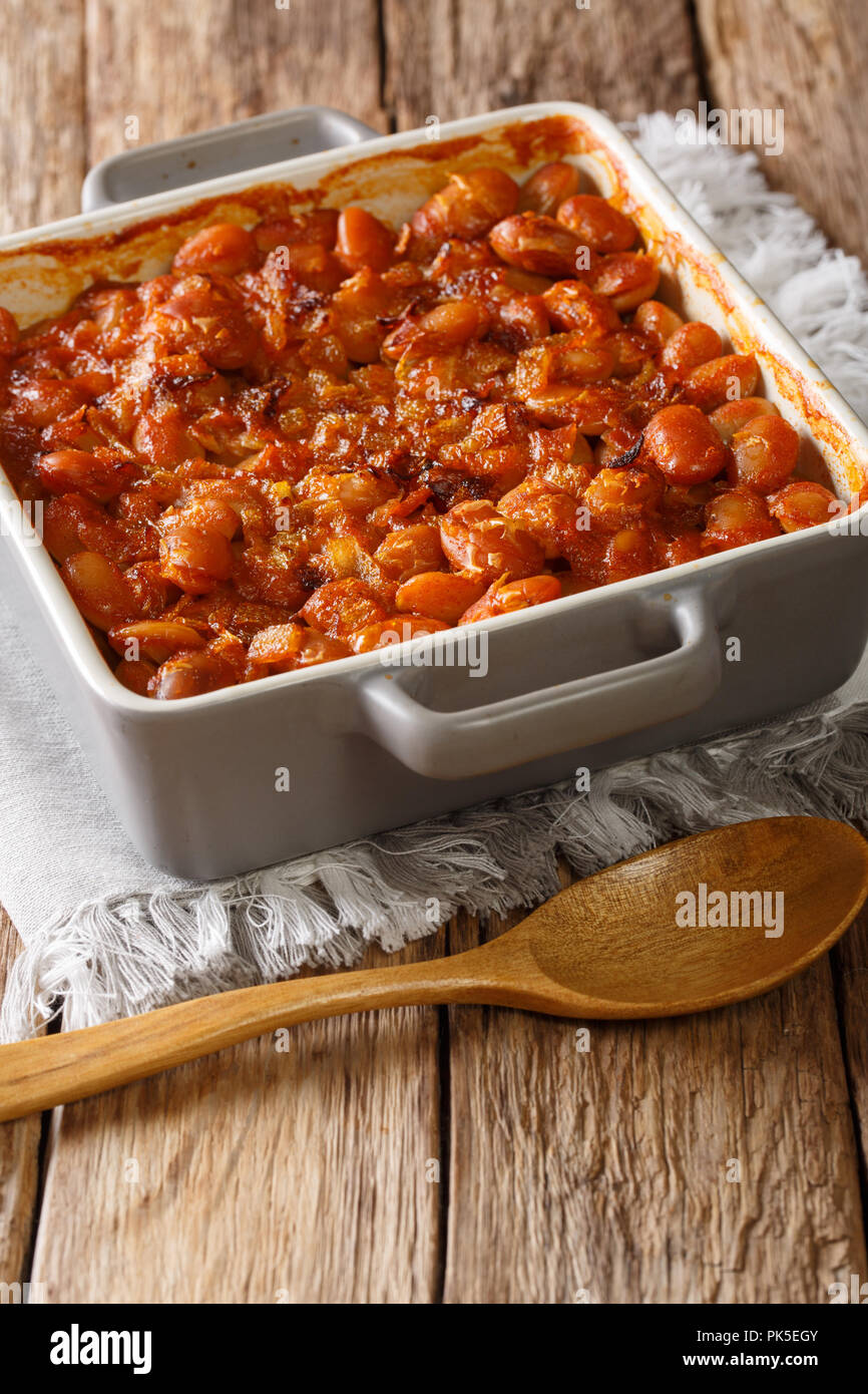 Serbian food: prebranac baked beans with onion close-up in baking dish on a table. vertical Stock Photo