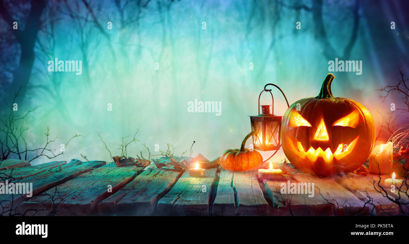 Halloween - Jack O' Lanterns And Candles On Table In Misty Night Stock ...