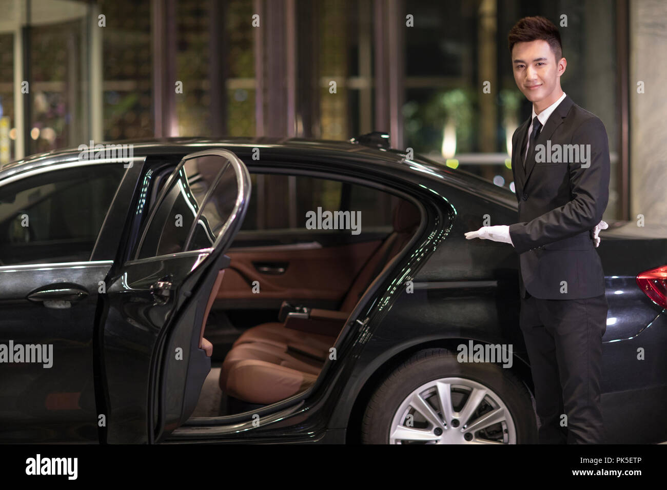 Chauffeur opening car door for passenger Stock Photo Alamy