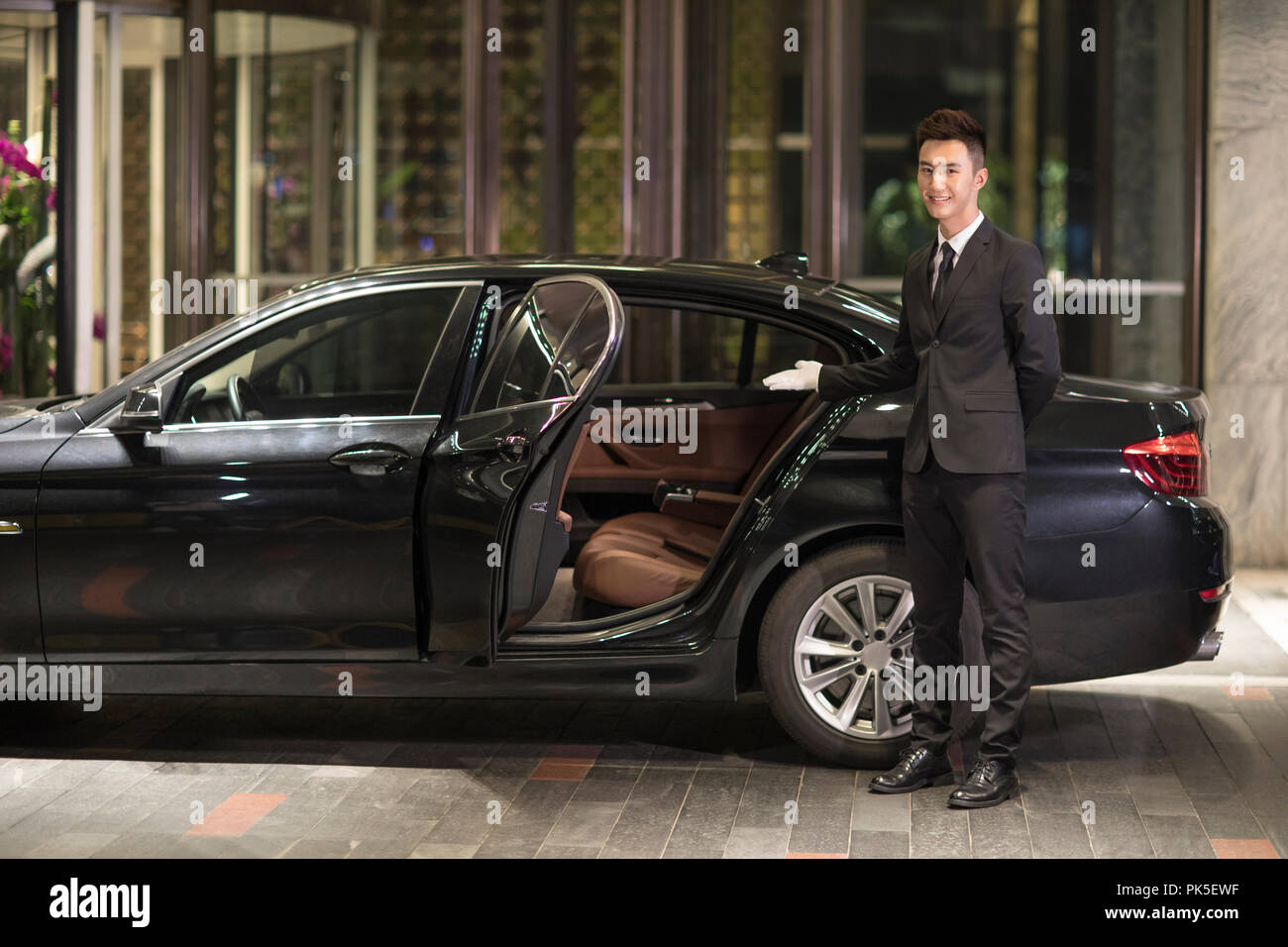 Chauffeur opening car door for passenger Stock Photo Alamy