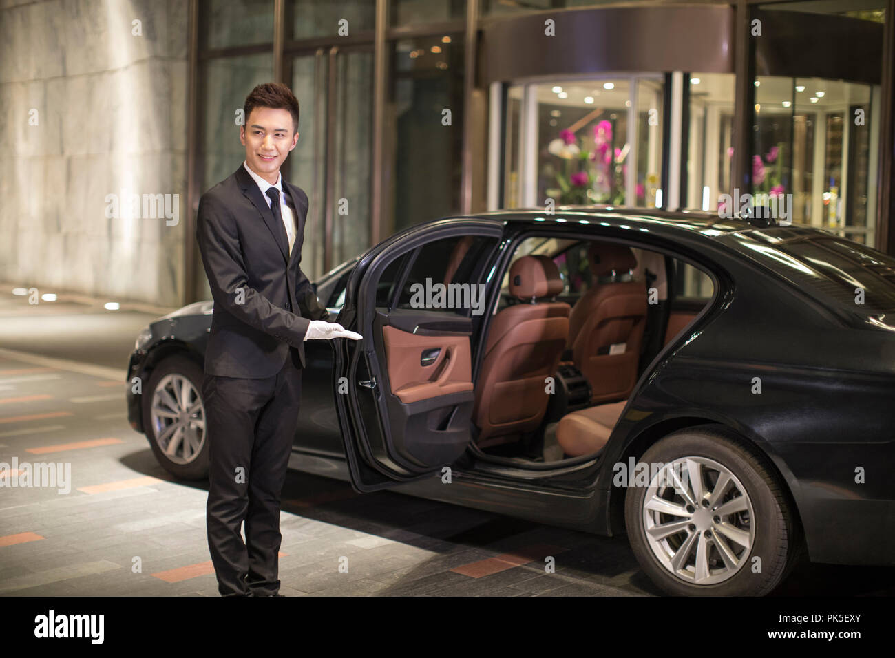 Chauffeur opening car door for passenger Stock Photo Alamy