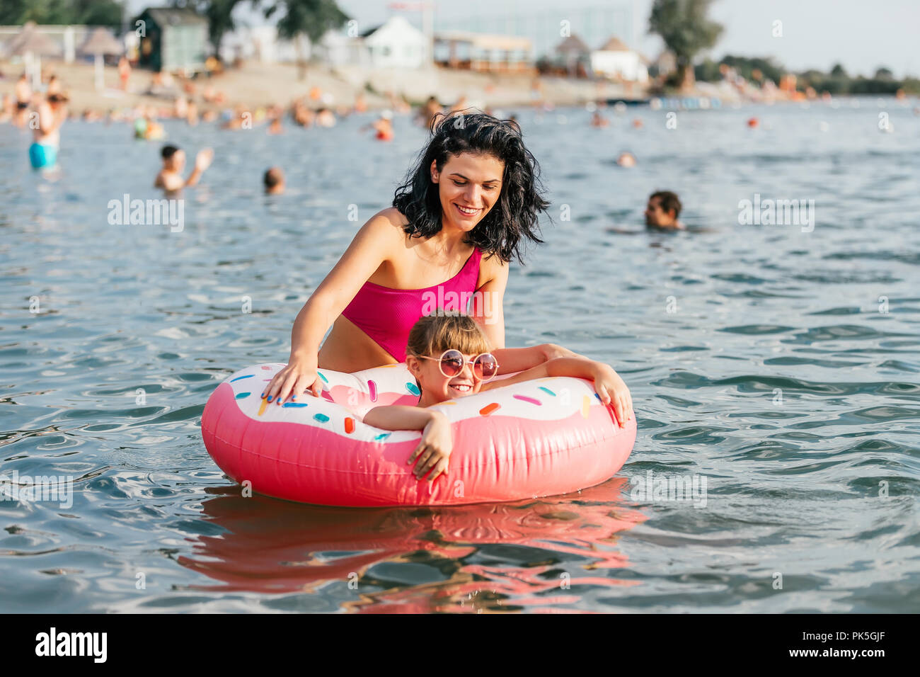 Mom and daughter swiming and relaxing in the water on an inflatable donut. Summer holiday Stock Photo