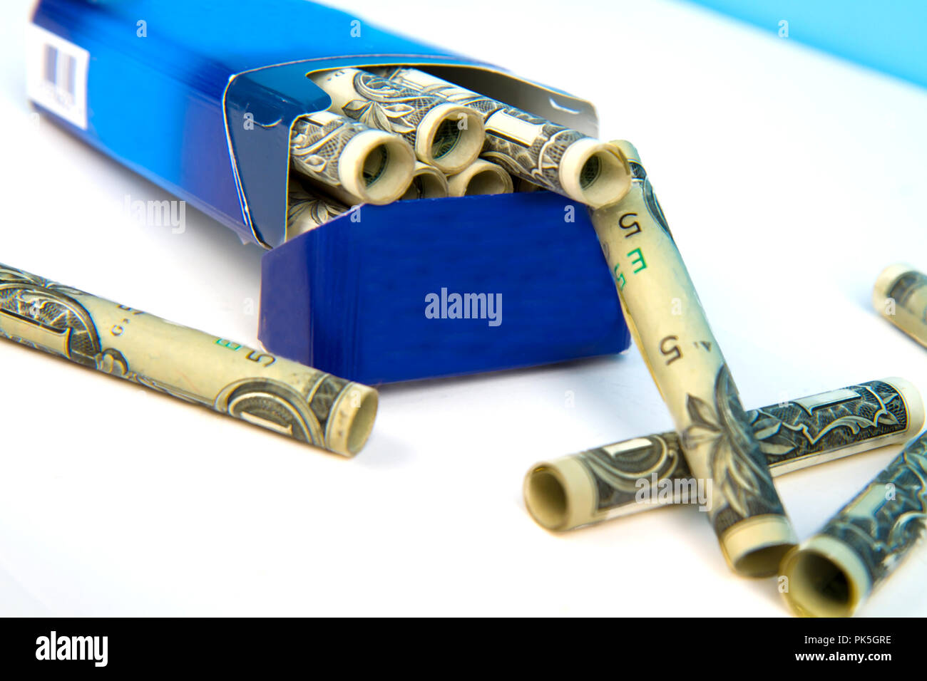 Concept Image of smoking cigarettes costing a lot of money. Dollar bills  rolled up as though they are cigarettes Stock Photo